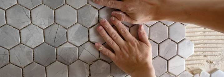 Person verfugt sechseckige Fliesen